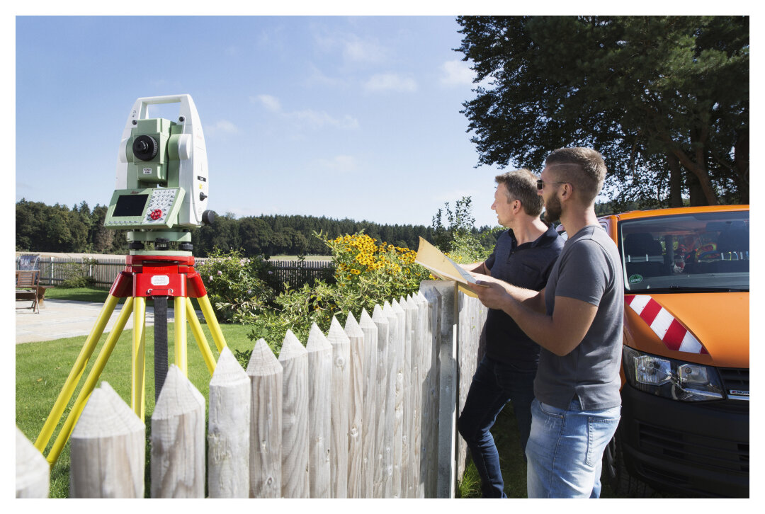 zwei Mitarbeiter des Vermessungsamts bei einer Besprechung im Außendienst